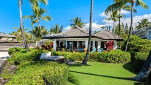 una casa con palme e una panchina nel cortile di Kona Bay Estates 23 a Kailua-Kona