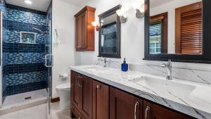 un bagno con due lavandini, un water e una doccia di Kona Bay Estates 23 a Kailua-Kona Altre 49 foto