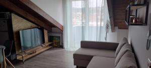 a living room with a couch and a television at La Mansarda in Quarto