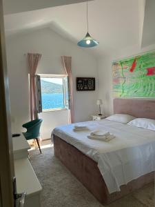 een slaapkamer met een groot bed en een raam bij House with a private beach in Slano