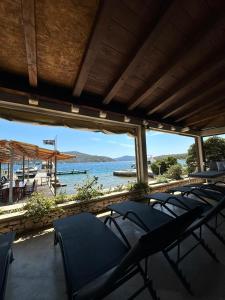 een groep stoelen op een veranda met uitzicht op het water bij House with a private beach in Slano