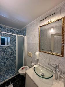 een badkamer met een toilet, een wastafel en een spiegel bij House with a private beach in Slano