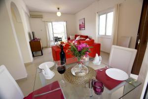 a living room with a table with a vase of flowers at The Love Nest in Pissouri +12 photos
