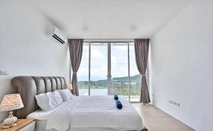 a bedroom with a bed and a large window at Seaview Oasis - 4BR near Beach - Koh Samui in Ban Khlong Mae Nam