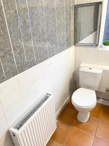 a bathroom with a white toilet and a radiator at Kirkby House in Moorthorpe