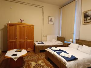 a room with two beds and a cabinet in it at Borostyán Vendégház in Nagykőrös