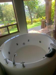 a large white bath tub in a room with a window at Zidada Hotel and Chalets in Bernal +165 photos