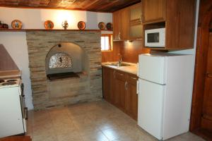 cocina con horno de ladrillo y nevera blanca en Lazarovata House en Rebrevtsi