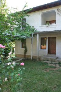 una casa con un patio con flores rosas delante de ella en Lazarovata House en Rebrevtsi