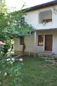 una casa con un giardino con fiori rosa di fronte di Lazarovata House a Rebrevtsi