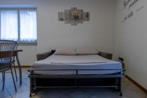 un letto in una stanza accanto a un muro di Casa La Corte a Rovereto