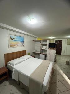 a bedroom with a large bed and a desk at Pousada Laranja Durigon in Natal +80 photos