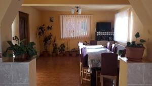 a dining room with a table and chairs and plants at Cabana Claudia Briciu in Arieşeni