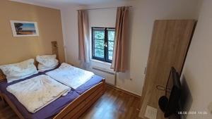 a small bedroom with a bed and a window at Haus Eckstein in Lohme