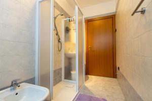 un bagno con lavandino e doccia con porta in vetro di Casa La Corte a Rovereto Altre 15 foto