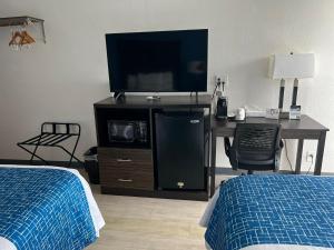 a bedroom with a desk with a tv and a bed at Travelodge by Wyndham Gallipolis in Gallipolis