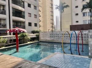 贝伦Resort Parc Paradiso的建筑物旁边有带遮阳伞的游泳池