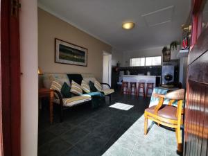 a living room with a couch and a kitchen at LalaWiGuesthouse in Langebaan