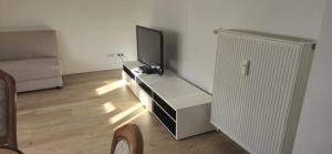 a living room with a flat screen tv on a dresser at Ferienwohnung Hausnummer 1, Kontaktloser Self check-in in Zweibrücken