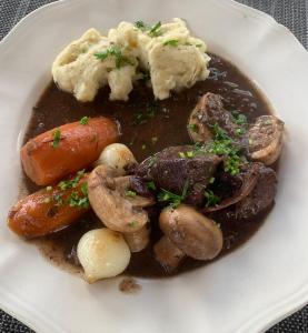 a plate of food with mushrooms and mashed potatoes at Chambre proche Stade de France, métro à 5min in Saint-Denis +32 photos