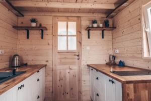a kitchen with wooden walls and wooden counters at JEZIORAKI Wyjątkowe domki 500m od jeziora Nowa Jedlanka in Uścimów