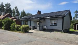 万斯布鲁Gästhuset 32的一间黑色屋顶的灰色小房子