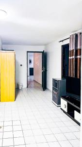 ein leerer Raum mit weißem Fliesenboden und einer Tür in der Unterkunft Tranquil residence Hotel in Abidjan + 17 Fotos