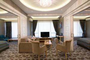 um quarto de hotel com um sofá e uma televisão em The Berussa Hotel em Bursa