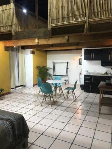 a room with a table and chairs and a kitchen at Hostal Luz de Luna Nuyoo in Oaxaca City