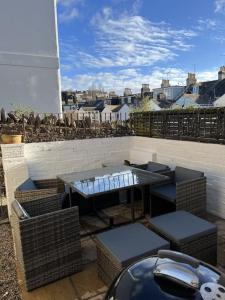 Un patio con una mesa y sillas en un balcón. en Luxury holiday home in Brixham, en Brixham