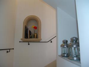 a shelf with a vase with a flower in it at Il Cavaliere in Noto