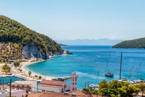 a view of a beach with a church and the ocean at Ioanna House - Seaside Living, Walk to Beach in Skopelos Town