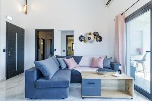 a living room with a blue couch and pink pillows at Ioanna House - Seaside Living, Walk to Beach in Skopelos Town