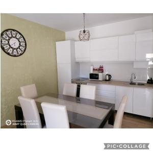 a kitchen with a table and chairs and a clock at Apartman SATO in Brčko