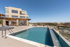 a villa with a swimming pool and a house at Mousonas Luxury Living in Kámpos