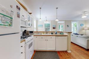 a kitchen with white cabinets and white appliances at Bella Beach Home in Depoe Bay +16 photos