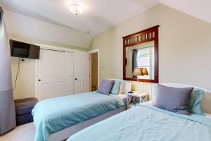 a bedroom with two beds and a mirror at Bella Beach Home in Depoe Bay