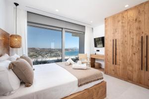 Un dormitorio con una cama grande y una ventana grande. en Mousonas Luxury Living, en Kámpos 102 fotos más