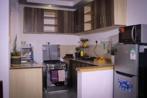 une cuisine avec des appareils en acier inoxydable et des armoires en bois dans l'établissement Summit View Suite - A two bedroom Apartment, à Nanyuki 2 autres photos