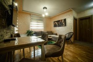 ein Wohnzimmer mit einer Couch und einem Tisch und Stühlen in der Unterkunft Jekaa in Zlatibor