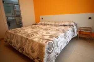カザラーノにあるB&B Le Parmenteのオレンジ色の壁のベッドルーム1室