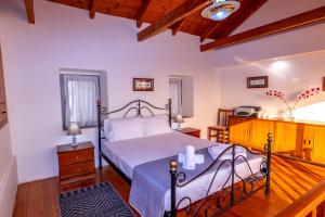 a bedroom with a bed and a wooden floor at Evanthia's mansion in Limbókhova