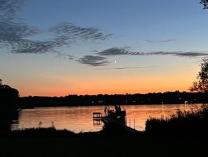 a sunset over a body of water with a dock at Lakefront Getaway- Hot Tub, Firepit & Fireplaces! home in Shoreview