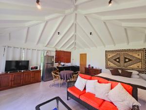 ein Wohnzimmer mit einer Couch und einem Bett in der Unterkunft The Estate Cottage in Savusavu