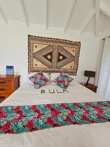 Schlafzimmer mit einem Bett mit dekorativem Kopfteil in der Unterkunft The Estate Cottage in Savusavu