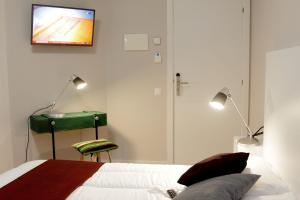 um quarto com uma cama e uma televisão na parede em Bressol B&B em Ripoll