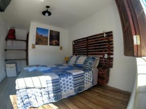 a bedroom with a bed with blue and white sheets at Suítes Aconchego - Pousada Rústica & Café da Manhã Especial in Lençóis