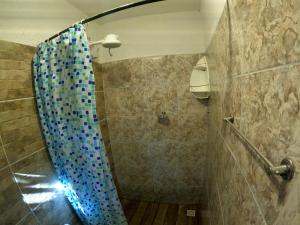een badkamer met een douche en een blauw douchegordijn bij Pousada Aconchego - Suítes Rústicas e Privativas in Lençóis +28 foto's