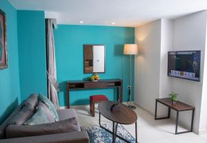 sala de estar con pared de acento azul en Souaré Premium Hôtel, en Conakry