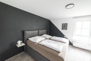 a bedroom with a bed with a black wall at Wohnen auf privater Reitanlage in Münsingen